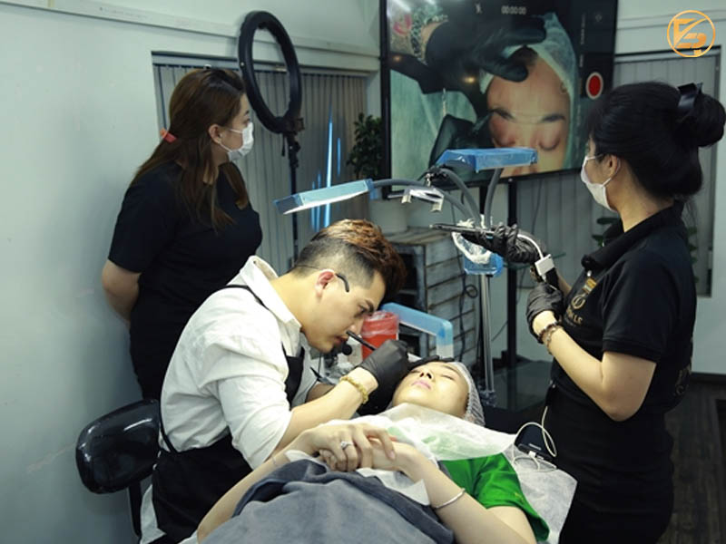 Giảng viên trực tiếp thực hành kỹ thuật phun thêu cho học viên quan sát tại địa chỉ học phun môi uy tín.