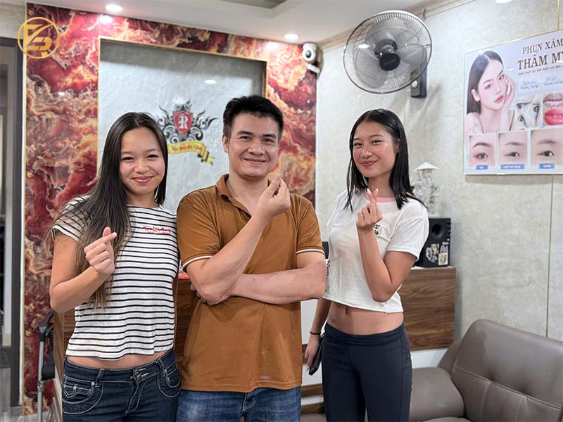 Khách hàng chụp ảnh kỷ niệm cùng chuyên gia tại không gian đón tiếp của địa chỉ xăm chân mày phong thủy chất lượng.