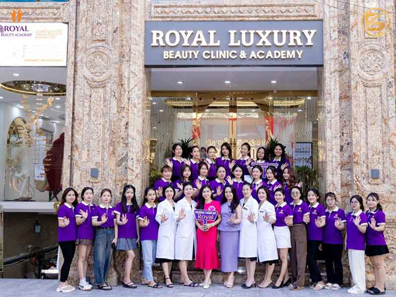 Tập thể đội ngũ bác sĩ, chuyên gia và học viên chụp ảnh kỷ niệm trước mặt tiền Royal Luxury Beauty Clinic & Academy.
