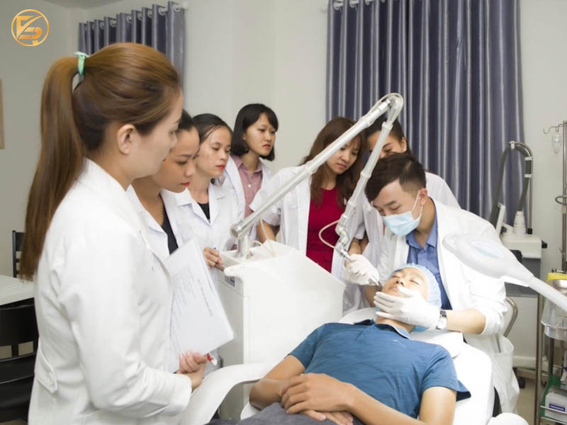 Bác sĩ đang thực hành thao tác laser da mặt trên khách hàng trước sự quan sát trực tiếp của nhóm học viên