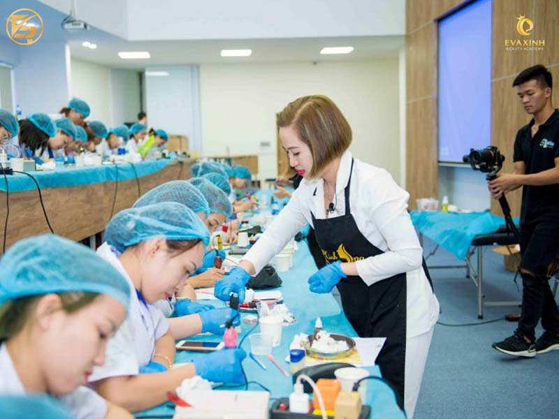 Giảng viên tại Eva Xinh Beauty Academy đang trực tiếp hướng dẫn đông đảo học viên thực hành kỹ thuật phun xăm thẩm mỹ